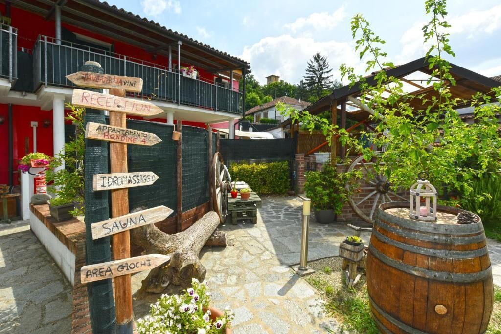 A rustic outdoor area with a wooden signpost indicating amenities like a sauna and a massage area.