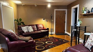 A living room with a brown leather sofa, a matching armchair, a coffee table, and a floor lamp. - Spacious 4-bedroom house in perfect Marshall for your getaway (Marshall)