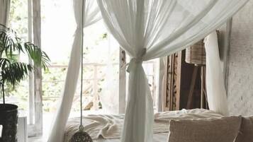 Un dormitorio con cama con dosel, un farol colgante y una planta en maceta.