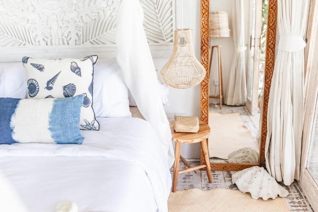 A bed with a canopy, a bedside lamp, and a decorative pillow.