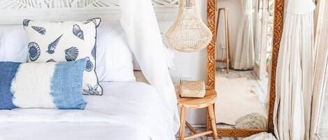 A bed with a canopy, a bedside lamp, and a decorative pillow.