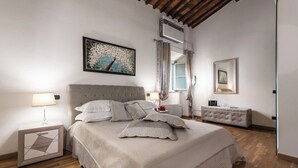 A bedroom with a large bed, a nightstand, a dresser, and a ceiling fan. - Giotto (Matraia)