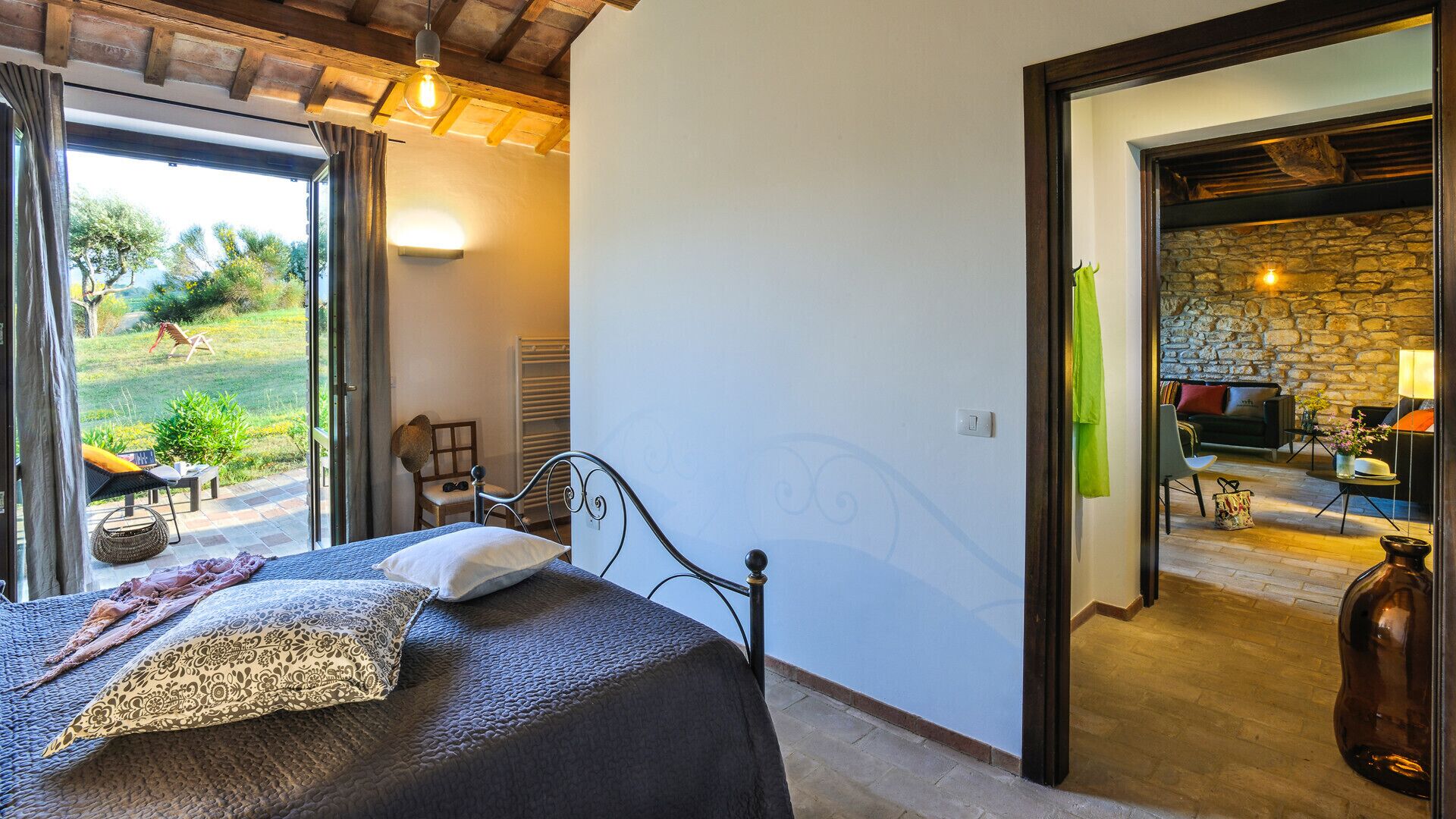 Une chambre à coucher avec un lit, une chaise et une vue sur l’extérieur.