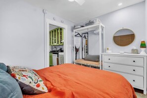 A bedroom with a bed, a dresser, a wardrobe, and a round mirror. - Alpine Edge, Top-Floor Ski Condo with Mountain Views adjacent to Ski Area (Steamboat Springs)