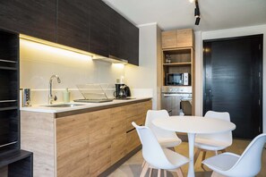 A modern kitchen with a central island, white chairs, and built-in wooden cabinets. - 2BR/1BA Apartment Perfect for Families with Pool! (Ñuñoa)