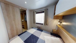A bedroom with a bed, a wardrobe, a window with curtains, and a bedside table. - Family vacation near La Palmyre zoo (Les Mathes)