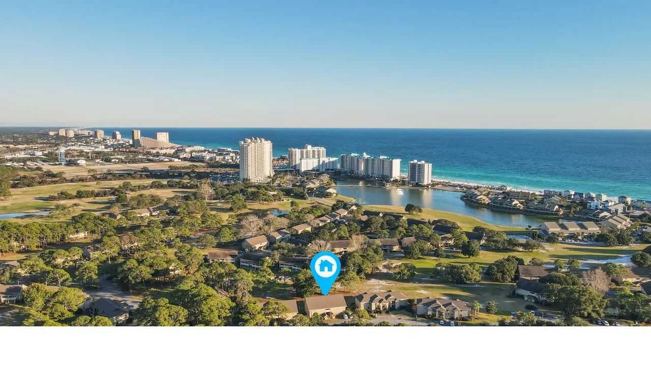 Een kuststadsbeeld met hoge gebouwen, een jachthaven en een golfbaan.