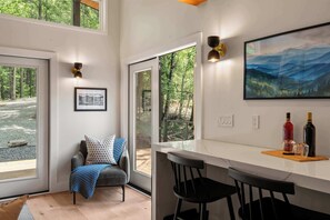 Ein modernes Interieur mit Essbereich, einer Sitzecke mit Blick und einem Bild an der Wand.