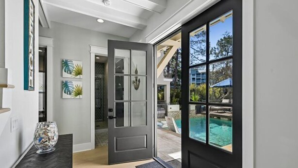 A modern entryway with a glass door leading to a pool area. - Stunning Vacation Home Just Steps to the Beach! (Hilton Head Island)