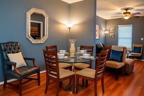 A dining area with a glass table, wooden chairs, and a blue wall. - Signature Reserve Atlanta Luxury 3BR Townhome Near ATL Airport Sleeps 6 (Atlanta)