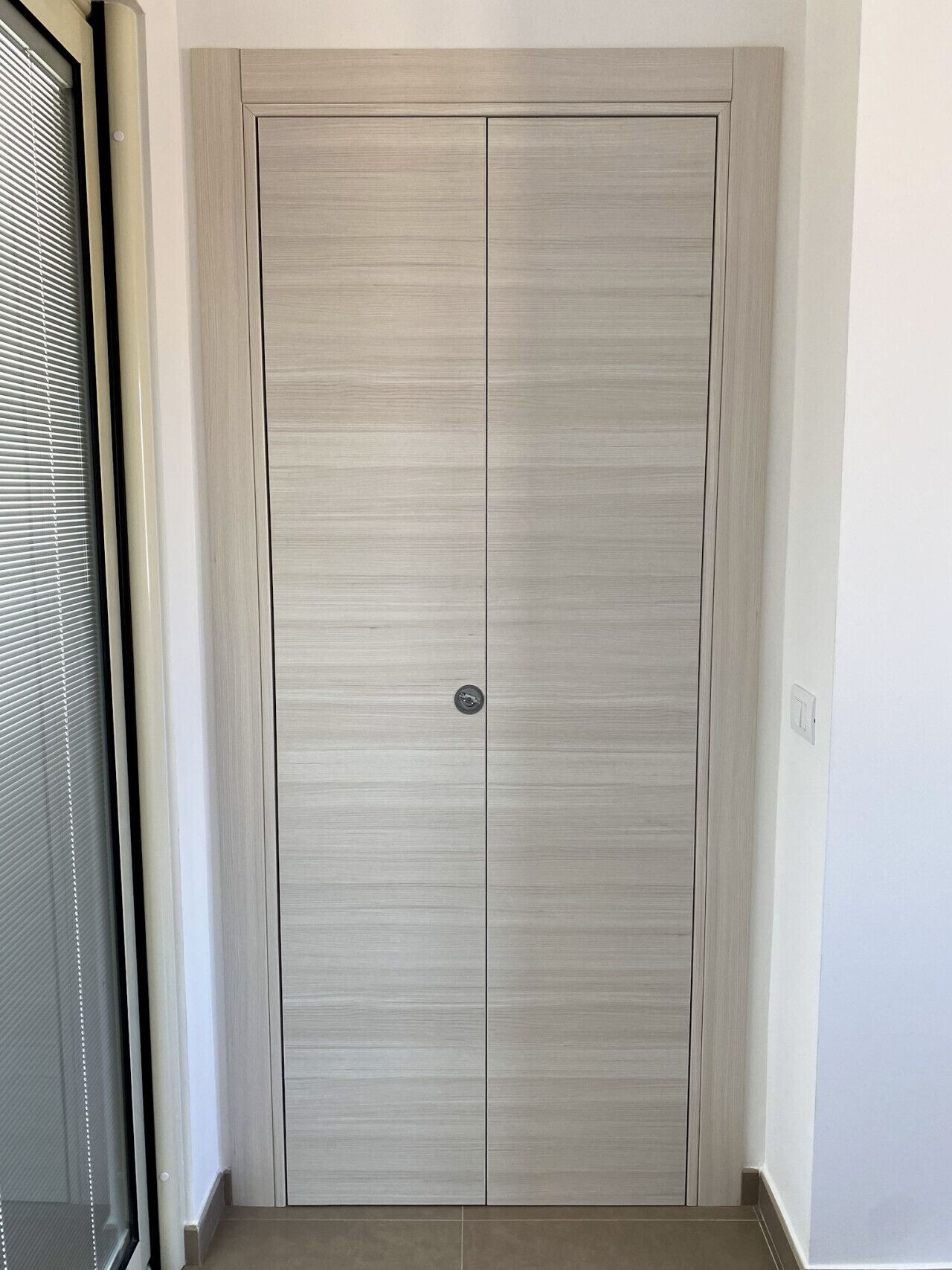 Um guarda-roupa fechado com puxador metálico, porta deslizante e um pequeno cadeado circular.