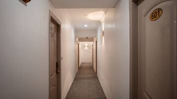 A narrow hallway with a carpeted floor, white walls, and doors numbered 601 and 602.