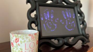 A decorative frame with a floral pattern and a candle with "LOVE" written on it.