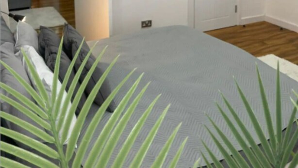 Ein modernes Schlafzimmer mit einem Bett, einem Nachttisch und einem Beistelltisch.