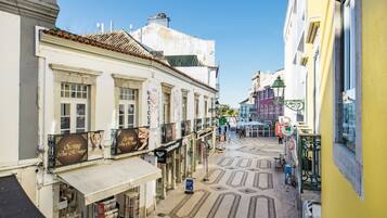 Una calle estrecha flanqueada por edificios, algunos con letreros de tiendas y restaurantes.