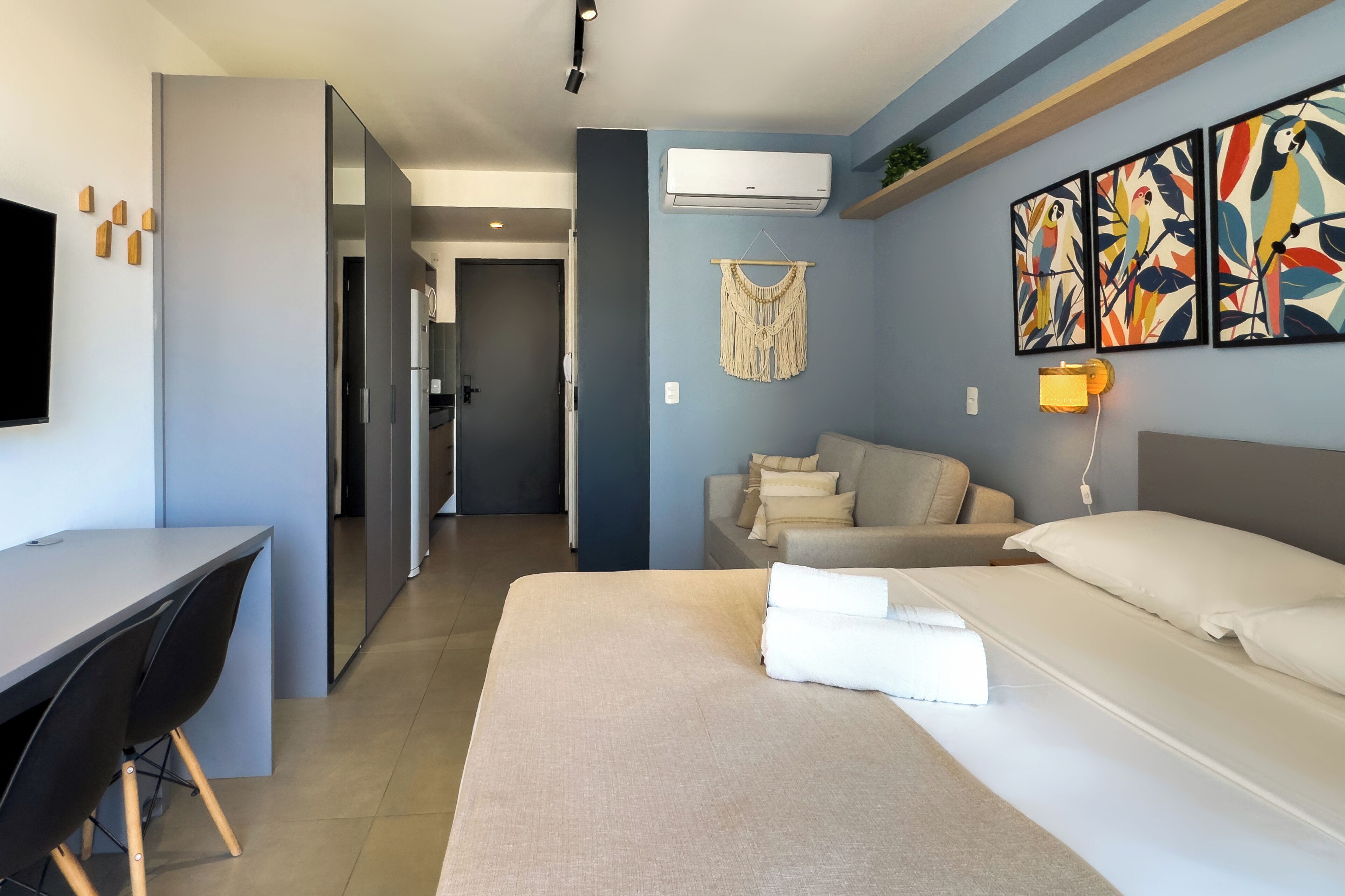 Une chambre d’hôtel moderne équipée d’un lit, d’un bureau, d’un canapé et d’une télévision.