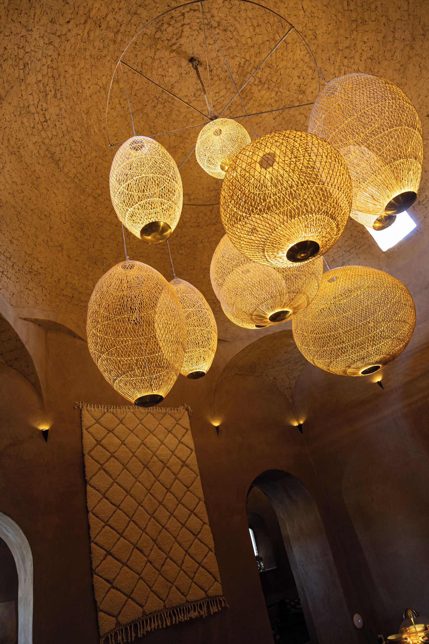 A ceiling with multiple spherical, woven light fixtures.