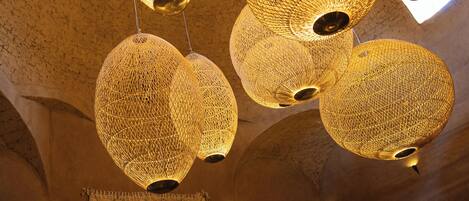 A ceiling with multiple spherical, woven light fixtures.