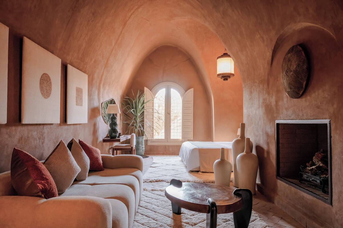 Una habitación acogedora y rústica con techo abovedado, chimenea, sofá y mesa de comedor.