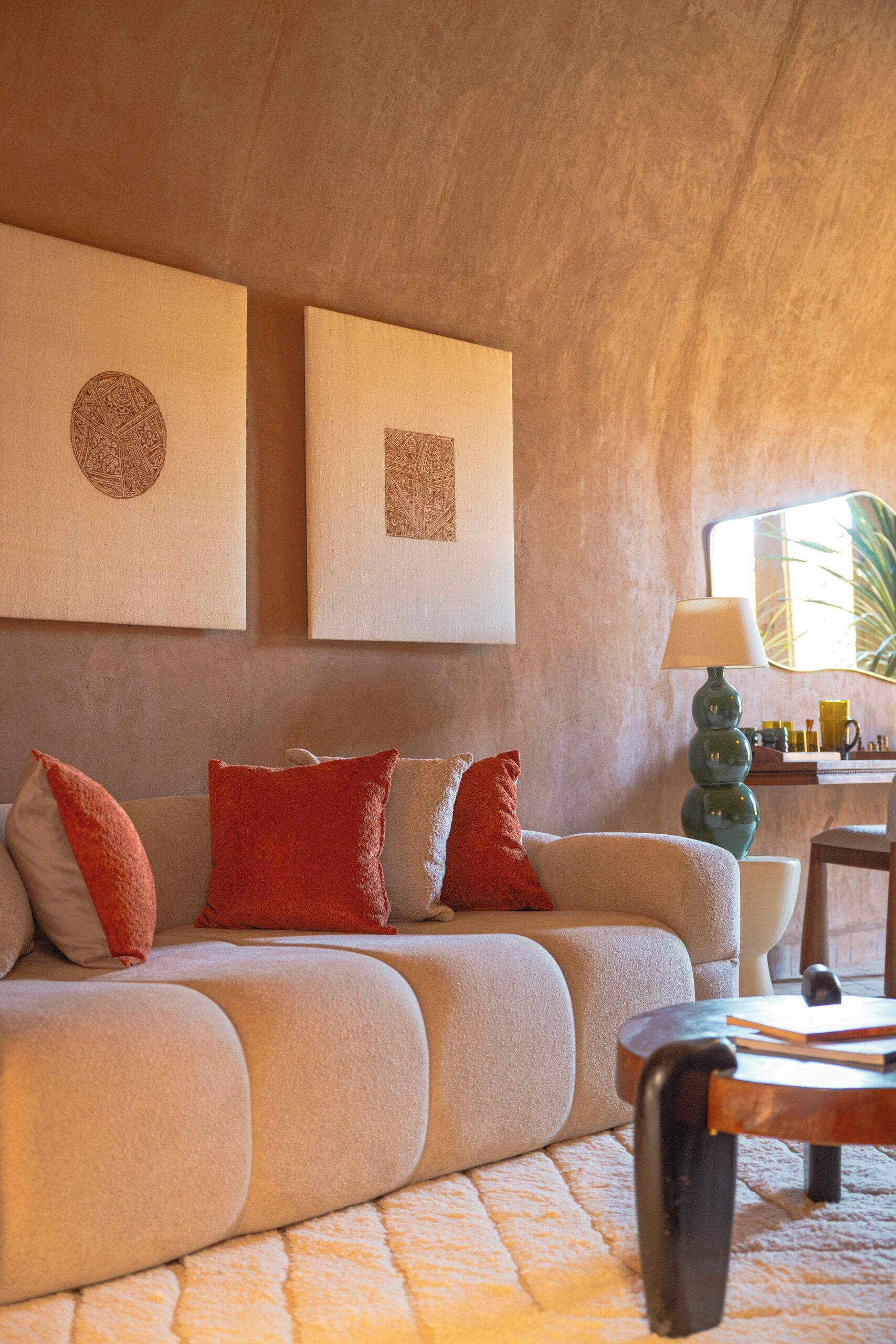 A living room with a sofa, pillows, a lamp, and artwork on the wall.