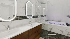 A modern bathroom with a white vanity, a large mirror with LED lights, a bathtub, and a shower area. - Lavie Maison : Marais Luxury, Hoy Tub & A/C (Paris)