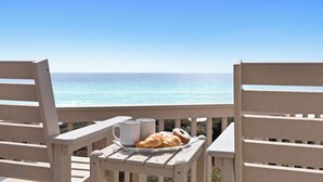 Ein Balkon mit Meerblick, ein Tisch mit Gebäck und zwei Tassen.
