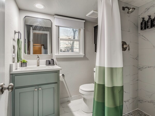 A bathroom with a toilet, sink, and shower. - Historic, 3-Bedroom 1920’s Home on Route 66 (Tulsa)