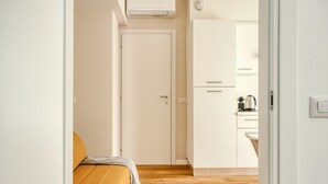 A room with a bed, a door, and a kitchenette area. - Hostmate - Milan - Imperia's Serenity - Romolo (Milan)
