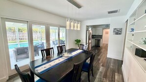 Un comedor con una mesa larga, sillas y vistas al exterior.