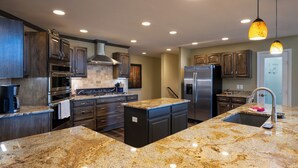 A modern kitchen with granite countertops, stainless steel appliances, and dark wood cabinetry. - Enjoy private luxury at Pagosa Valley Views! (Pagosa Springs)
