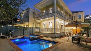 A two-story house with a swimming pool, outdoor furniture, and a staircase leading to the upper floor. - Luxury Estate w/ Private Pool, Spa & Gated Parking (New Orleans)