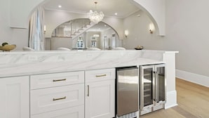 A spacious kitchen with a marble countertop, white cabinetry, and a built-in stainless steel refrigerator. - Luxury Estate w/ Private Pool, Spa & Gated Parking (New Orleans)