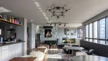 A modern interior with a bar area, seating, and large windows.