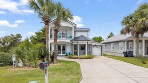 A two-story house with a balcony, a garage, and a well-maintained lawn. - Blue Mountain Home, Pet friendly, Pool, 4 Bikes, Beach (Santa Rosa Beach)