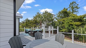 A deck with a round table and chairs, a covered seating area with cushions, and a view of a house and trees. - Blue Mountain Home, Pet friendly, Pool, 4 Bikes, Beach (Santa Rosa Beach)