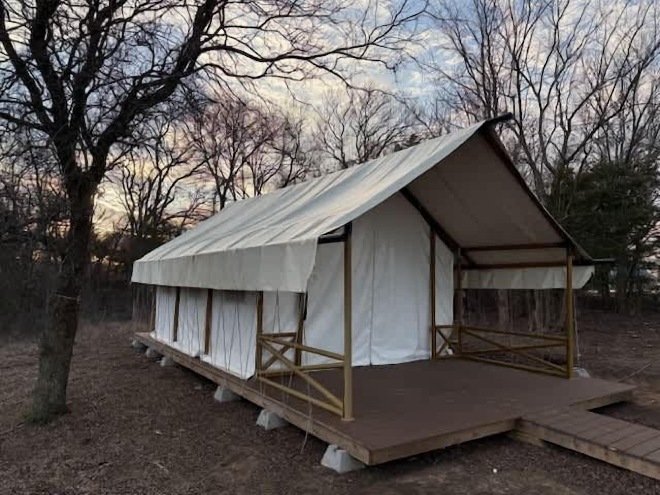 Een gelijkvloers A-frame gebouw met een overdekte veranda en een houten terras.