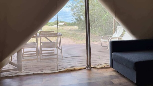 A cozy room with a view of an outdoor deck and chairs.