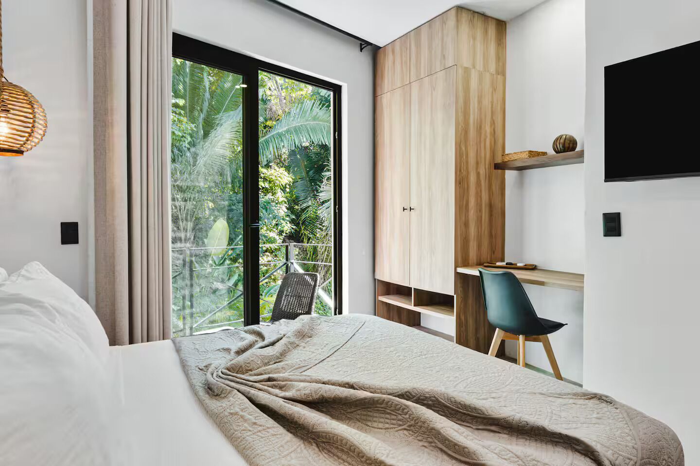 Une chambre moderne avec un grand lit, un bureau et une télévision.