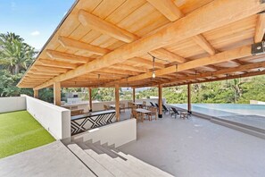 A covered outdoor area with a pool, seating, and a staircase leading to a higher level. - Northside Retreat - Infinity pool - Fast Wi-Fi (Sayulita)