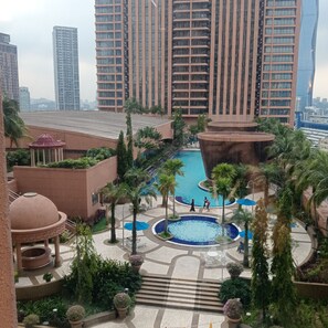 A resort with a central pool, palm trees, and a gazebo. - Popular suite at Times Square KL (Kuala Lumpur)