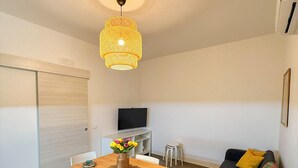 A compact living space with a dining area, a sofa, and a TV. - La Casetta (Stalettì)
