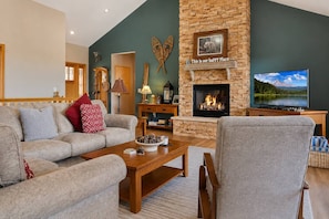 A living room with a fireplace, a television, and a sofa. - Hot Tub· Game Room· Sauna· Mtn Views· Dog Friendly (Breckenridge)