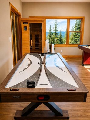 A pool table with a view of a forest through a window. - Hot Tub· Game Room· Sauna· Mtn Views· Dog Friendly (Breckenridge)