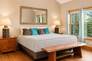 A bedroom with a bed, two bedside tables with lamps, a large mirror, a window with curtains, and a bench. - Hot Tub· Game Room· Sauna· Mtn Views· Dog Friendly (Breckenridge)