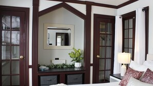 Un dormitorio con cama, cómoda, espejo y una planta en maceta.