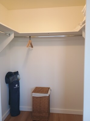 A storage closet with a hanging rack, a trash bin, and a wicker basket. - Newly remodeled fully furnished 2-bed 2-bath apartment located near the hospital (Santa Fe)