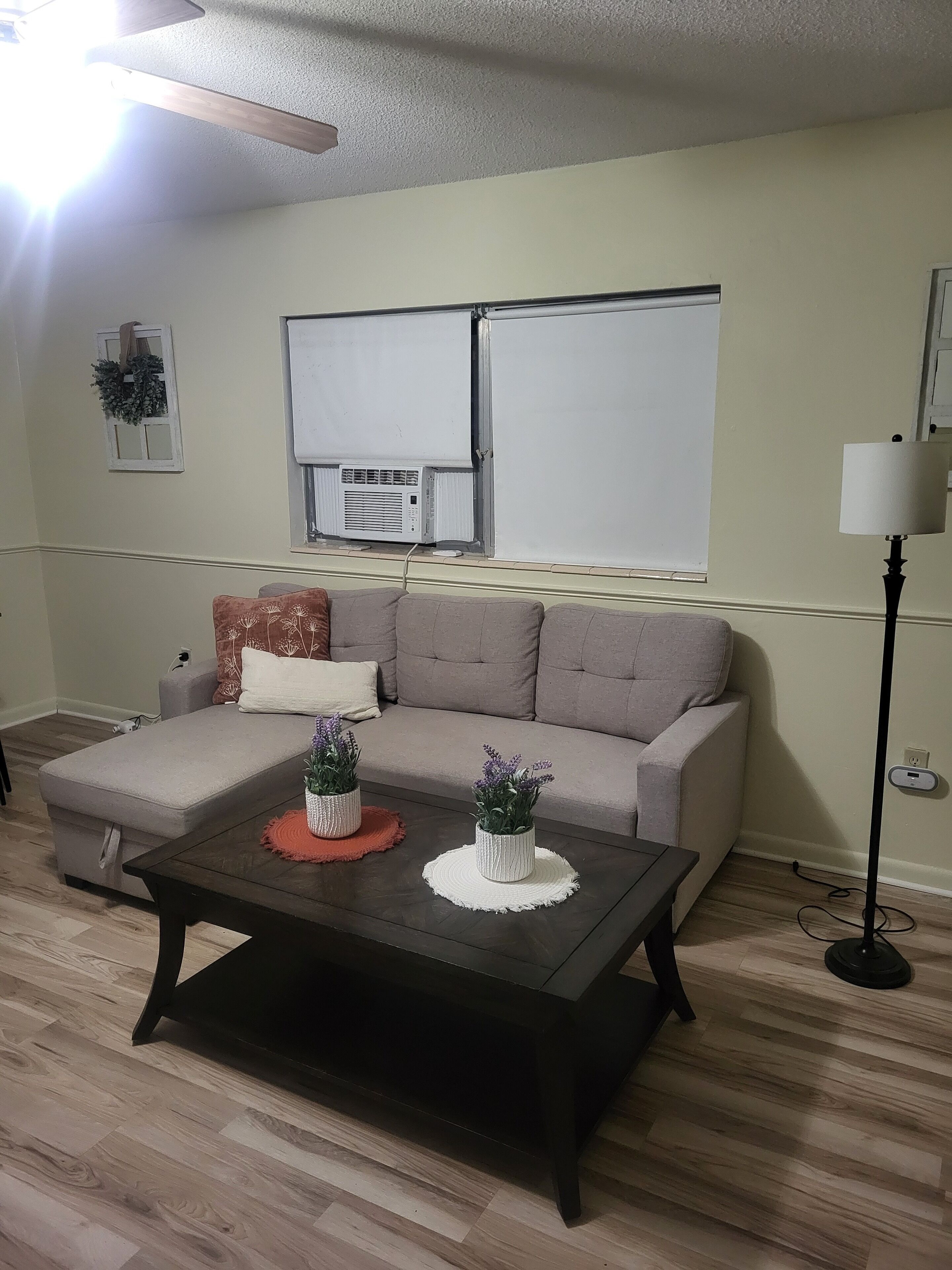 Una sala de estar con un sofá, una mesa de centro y una lámpara de pie.
