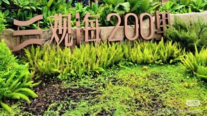 En moderne bygning med flere etager, med et skilt der angiver "Triple 200th Anniversary".