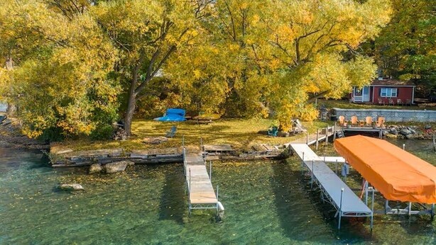 A clear lake with a dock and a covered seating area. - Cayuga Lake Cottage near Aurora - Wineries, Brewery, Trails and Lakefront. (Aurora)