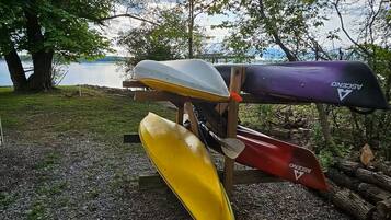 Unos botescanoas en un soporte junto a un lago.